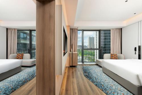 a hotel room with two beds and a large window at Holiday Inn Express Taizhou Jiaojiang in Taizhou