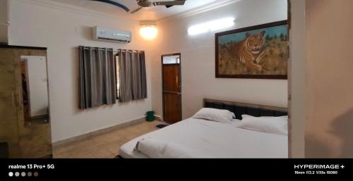 a bedroom with a bed and a picture of a tiger on the wall at Jayant Home Stay in Mount Ābu