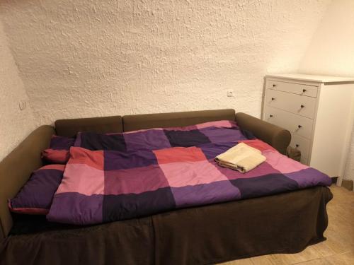 a bed with a quilt on it in a bedroom at Panoráma Apartman Alsóörs in Alsóörs
