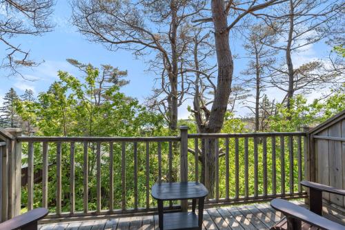 a chair on a deck with a fence at White Point Beach Resort in Summerville Centre