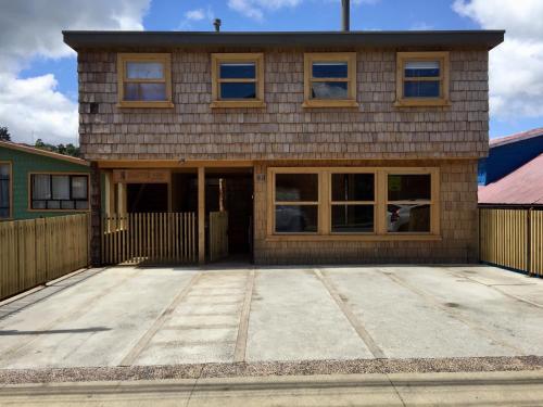 a house with a large driveway in front of it at Palafito Azul Apart Hotel in Castro
