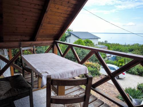 a balcony with a table and chairs and the ocean at Panoráma Apartman Alsóörs in Alsóörs