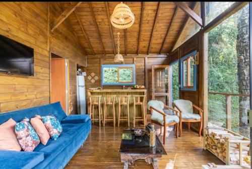a living room with a blue couch in a house at Cabanas do Rio in Alfredo Wagner