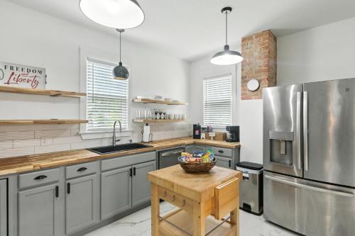 een keuken met roestvrijstalen apparatuur en een houten tafel bij Historic Elegance in the Heart of Elizabeth City home in Elizabeth City