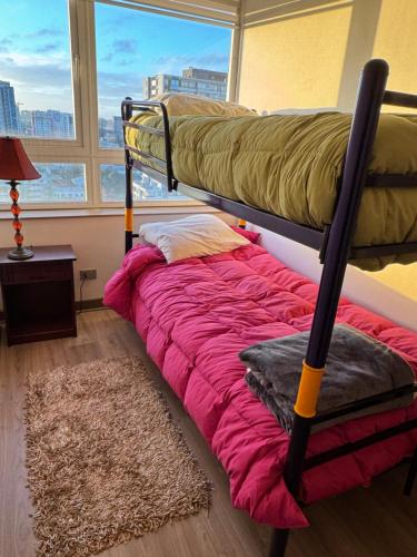 a bunk bed in a room with a window at Concep Centro Freiré-Tucapel in Concepción