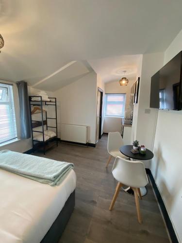 a bedroom with a bed and a table and a room at Wadham Suites in Liverpool