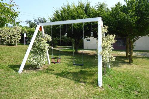 a swing set in a yard with flowers at Silea Apartments, Pool, Garden, Treviso in Silea