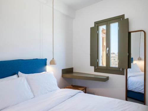 a bedroom with a bed and a window at Mykonian Shades in Ano Mera