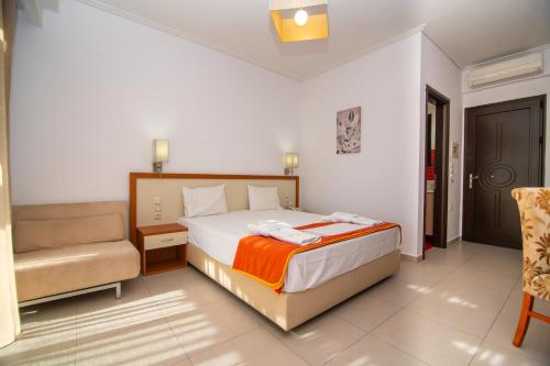 a hotel room with a bed and a chair at Riviera Perdika Hotel in Perdika