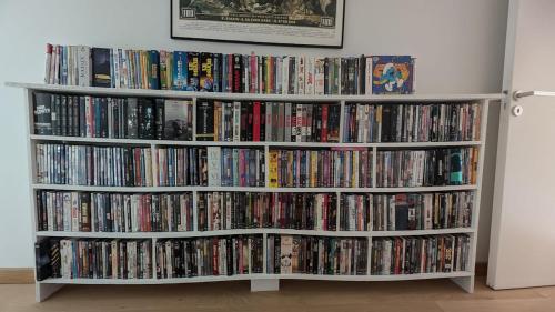 a book shelf filled with dvds and video games at Maison d'architecte, calme et nature réunis in Les Genettes