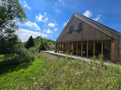 a barn with windows on the side of a field at Maison d'architecte, calme et nature réunis in Les Genettes