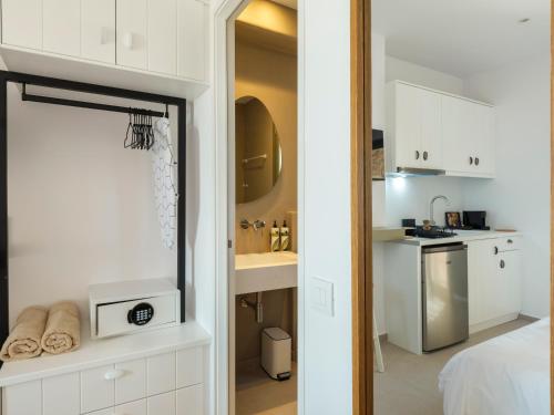 a small white kitchen with a sink and a microwave at Mykonian Shades in Ano Mera