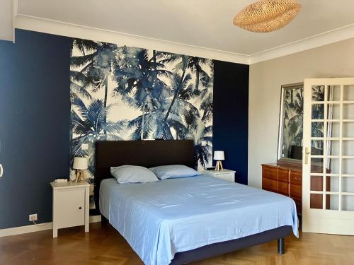 Un dormitorio con una cama con una pared azul. en l OSTAL BLAU, en Rodez