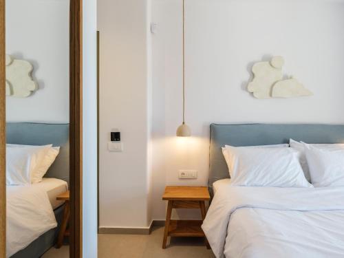 a bedroom with two beds and a mirror at Mykonian Shades in Ano Mera