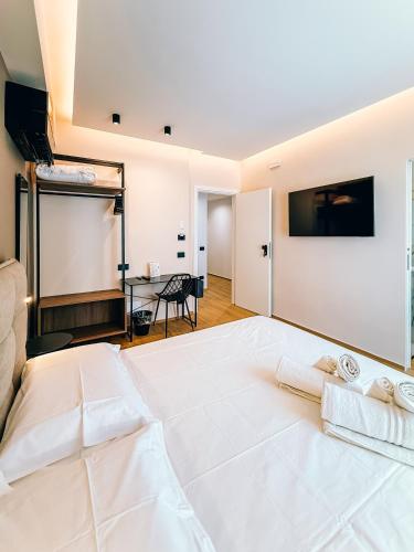 a large white bed with two towels on top of it at LumiaRooms B&B in Milazzo