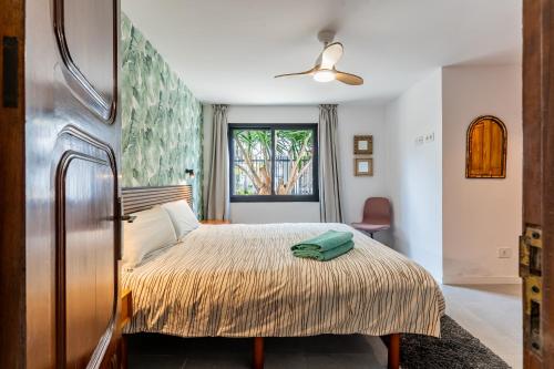 une chambre avec un lit avec une serviette verte dessus dans l'établissement Centric and bright apartment - Puerto de La Cruz, à Puerto de la Cruz