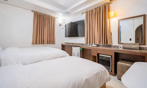 a hotel room with two beds and a mirror at Yeongdeungpo Ciel Hotel in Seoul