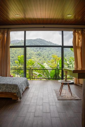 a bedroom with a bed and a large window at Vista Canaan Cabaña de montaña in Rivas