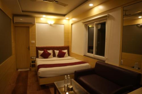a hotel room with a bed and a couch at Hotel Chariot Inn in Deoghar