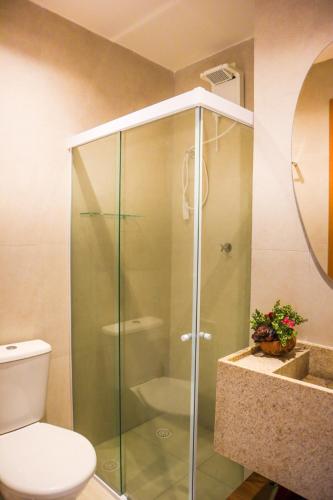 a glass shower in a bathroom with a toilet at Casa Guaimbê com Rooftop e piscina privativa in São Miguel dos Milagres