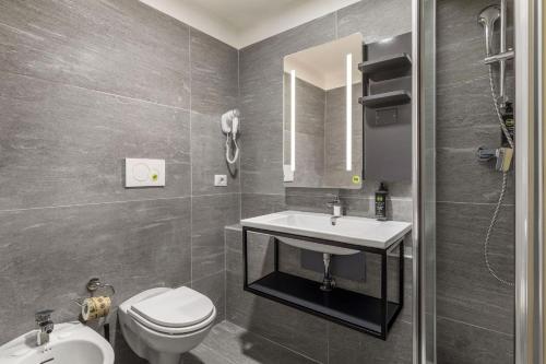 a bathroom with a sink and a toilet and a mirror at B&B HOTEL Milano Portello in Milan