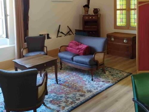 a living room with a couch and chairs and a table at L'ancien Tribunal in Tonnerre