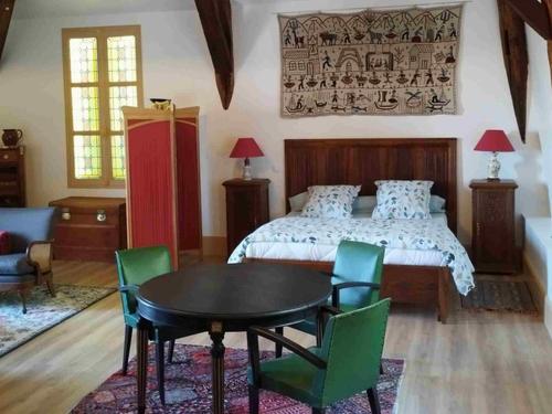 a bedroom with a bed and a table and chairs at L'ancien Tribunal in Tonnerre