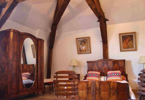 a bedroom with a wooden bed and a mirror at L'ancien Tribunal in Tonnerre