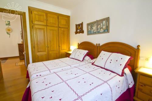 Un dormitorio con una cama grande con dos almohadas. en El Amanecer, en Comillas