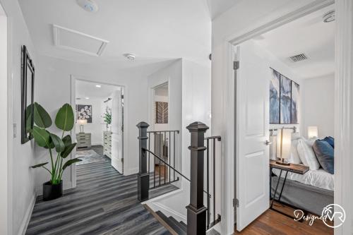 a hallway with white walls and a staircase with a bed at Luxury Retreat: Pool Games Basketball More in Largo