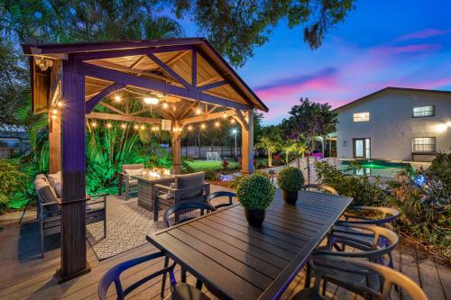 a patio with a wooden table and chairs at Luxury Retreat: Pool Games Basketball More in Largo
