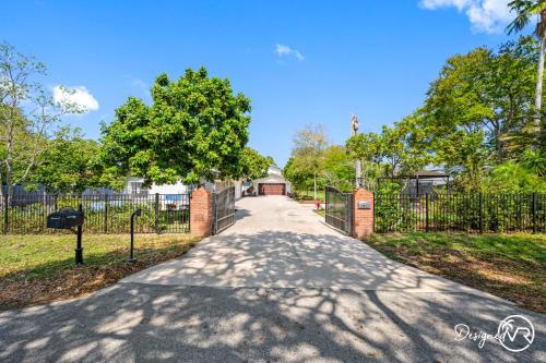 a driveway leading to a house with a fence at Luxury Retreat: Pool Games Basketball More in Largo