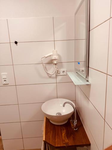 a bathroom with a sink and a mirror at Enns Sleep Gasthaus Backhendlstation in Enns