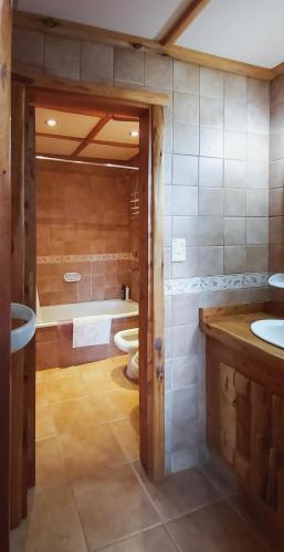 a bathroom with two sinks and a toilet and a tub at Cocos Cura Casas de montaña in San Carlos de Bariloche