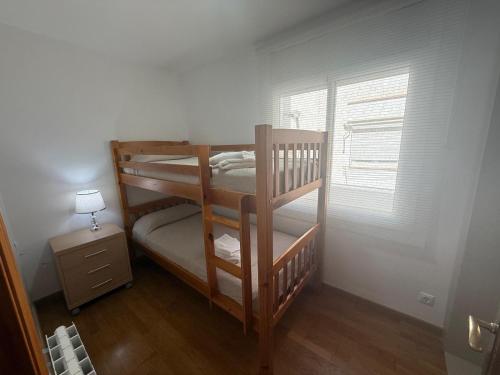 two bunk beds in a room with a window at Apartamento Ramon in Tarragona