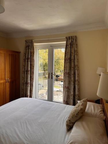 a bedroom with a white bed and a window at Springfield Country Hotel, Leisure Club & Spa in Wareham