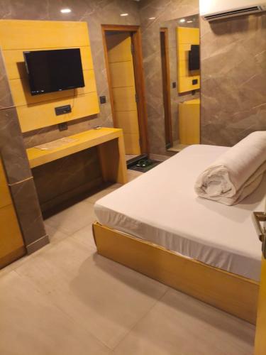 a bedroom with a bed and a tv on a wall at S R M Hotel Grand Shiva Just a Minute Away From New Delhi Railway Station and V F S Sivaji Stadium Metro Station in New Delhi