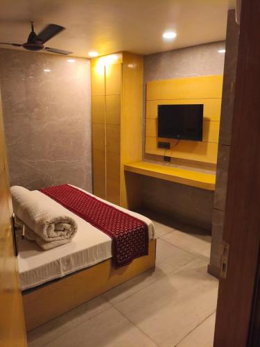 a small room with a bed and a flat screen tv at S R M Hotel Grand Shiva Just a Minute Away From New Delhi Railway Station and V F S Sivaji Stadium Metro Station in New Delhi