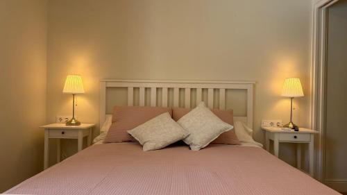 a bedroom with a bed with two lamps on two tables at Hotel Antiga in Calafell