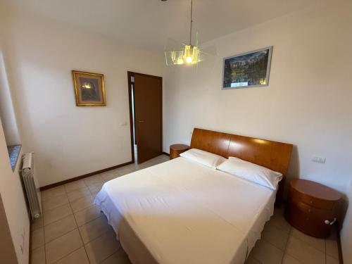 una camera da letto con un letto bianco in una stanza di La Quiete 30 Lake view apartment by Gardadomusmea a Tremosine Sul Garda