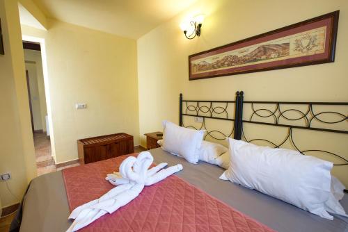 a bedroom with a bed with white sheets and pillows at Hostal San Pedro in Cuenca