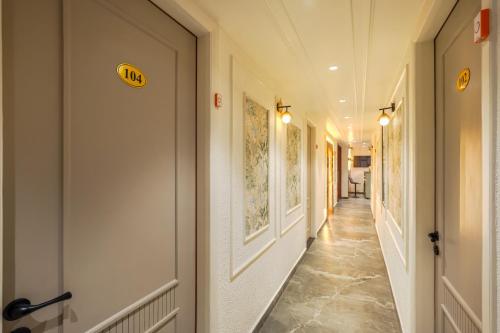 a hallway with white walls and a long hallway with yellow signs at Elegance A Boutique Stay in Amritsar