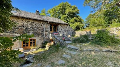 an old stone house in a yard with trees at B&B Bio et écolo du Besset in Yssingeaux