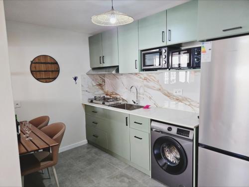a kitchen with a washing machine and a sink at Villa Soleil D’été in Blue Bay
