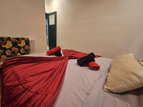 a bed with red and black pillows on it at Chez Paul au Rivet Paris in Le Plessis-Robinson
