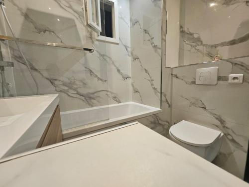a bathroom with a toilet and a sink and a tub at Chez Paul au Rivet Paris in Le Plessis-Robinson