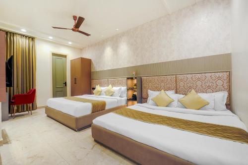 a hotel room with two beds and a chair at Elegance A Boutique Stay in Amritsar