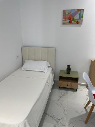 a bedroom with a bed and a table and a chair at Drymades Retreat, Dhërmi in Gjilek