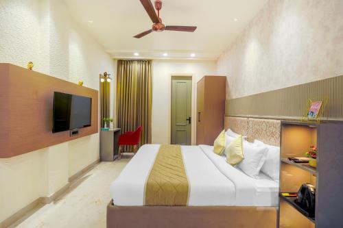 a hotel room with a bed and a flat screen tv at Elegance A Boutique Stay in Amritsar
