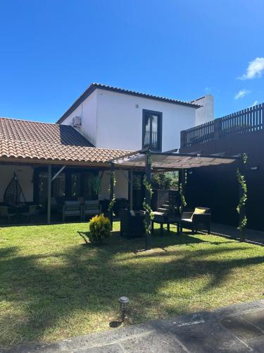 a house with a yard with a patio at Vila Rosario in Ponta Delgada